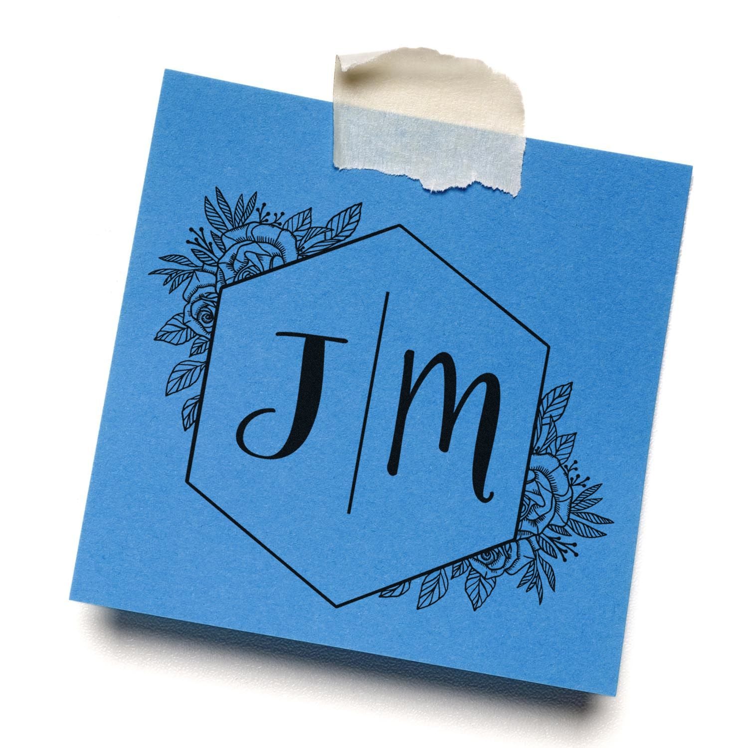 Blue stamp and seal card with black Jm monogram, floral border, and taped top edge.