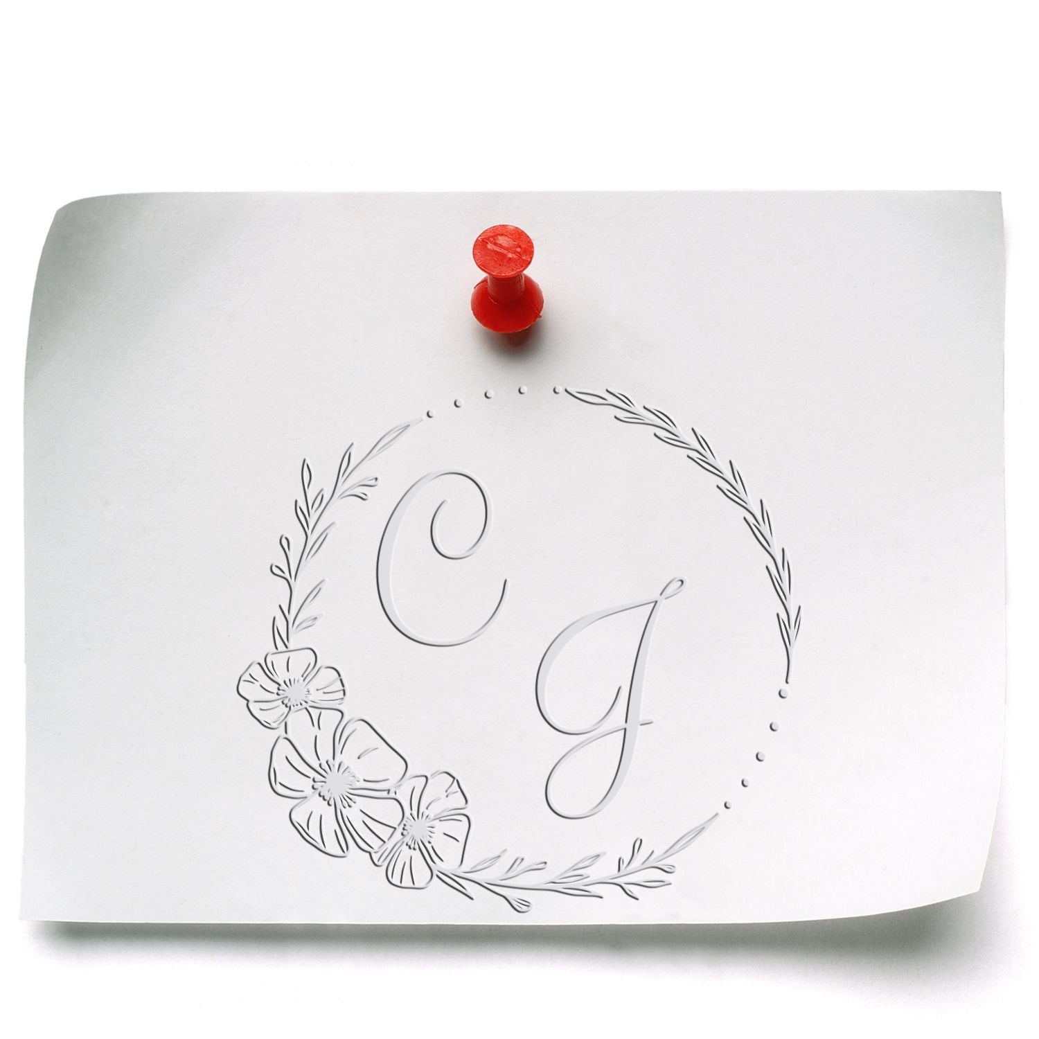 White embossed monogram seal with floral wreath and red stamp on paper