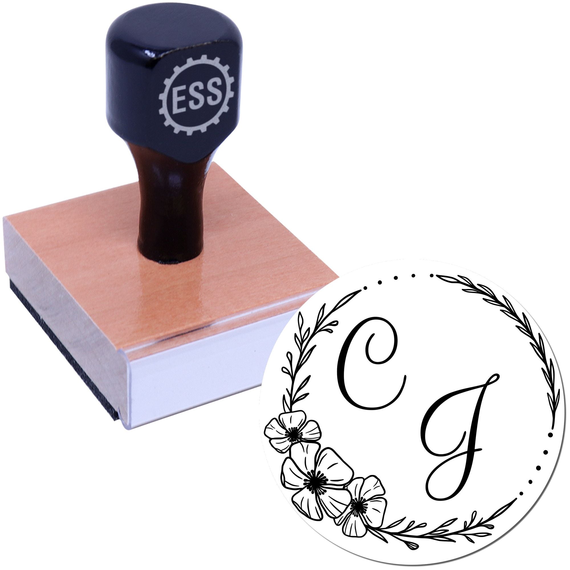 Black ESS rubber stamp on wooden block with white floral monogram seal featuring initials C and J