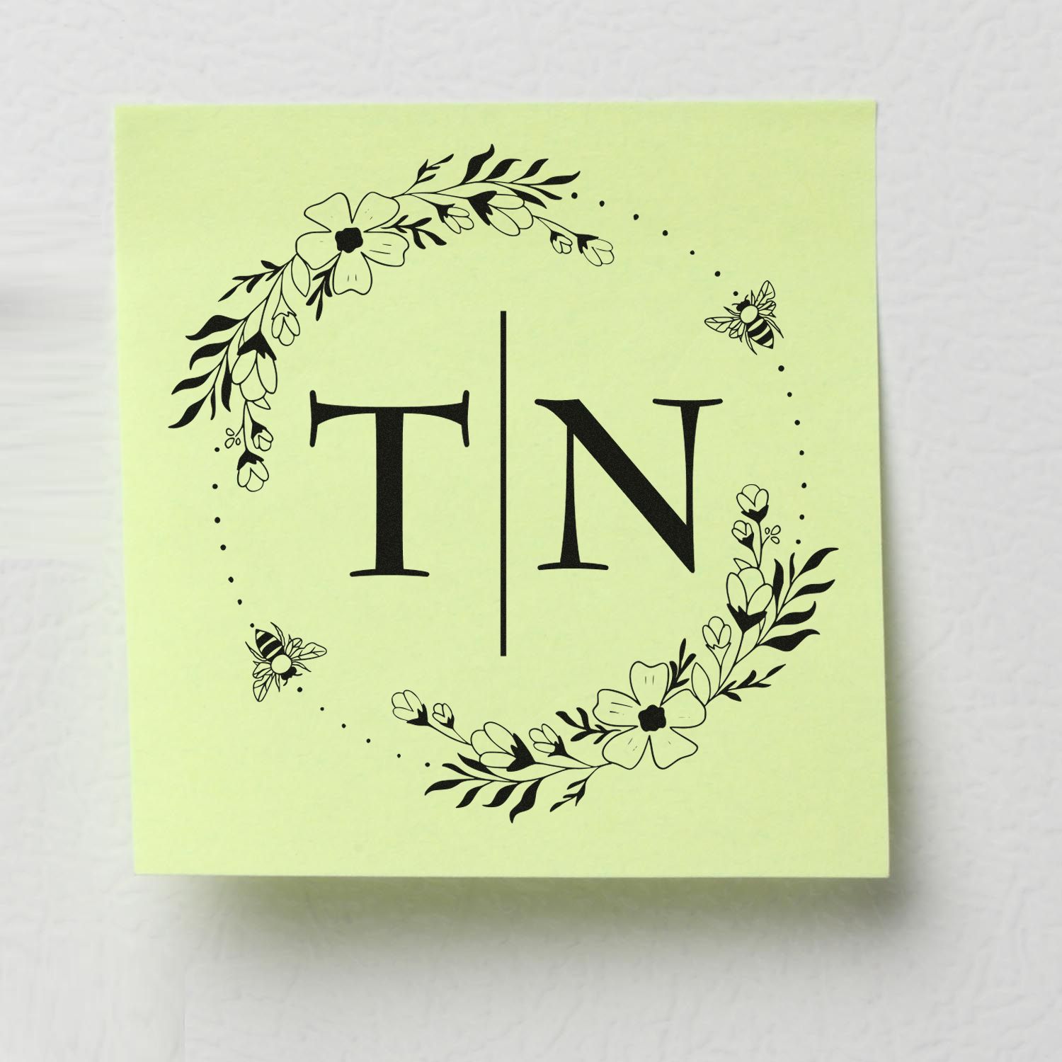 Custom stamp seal on pale green square card with black floral wreath, bees, and TN monogram.