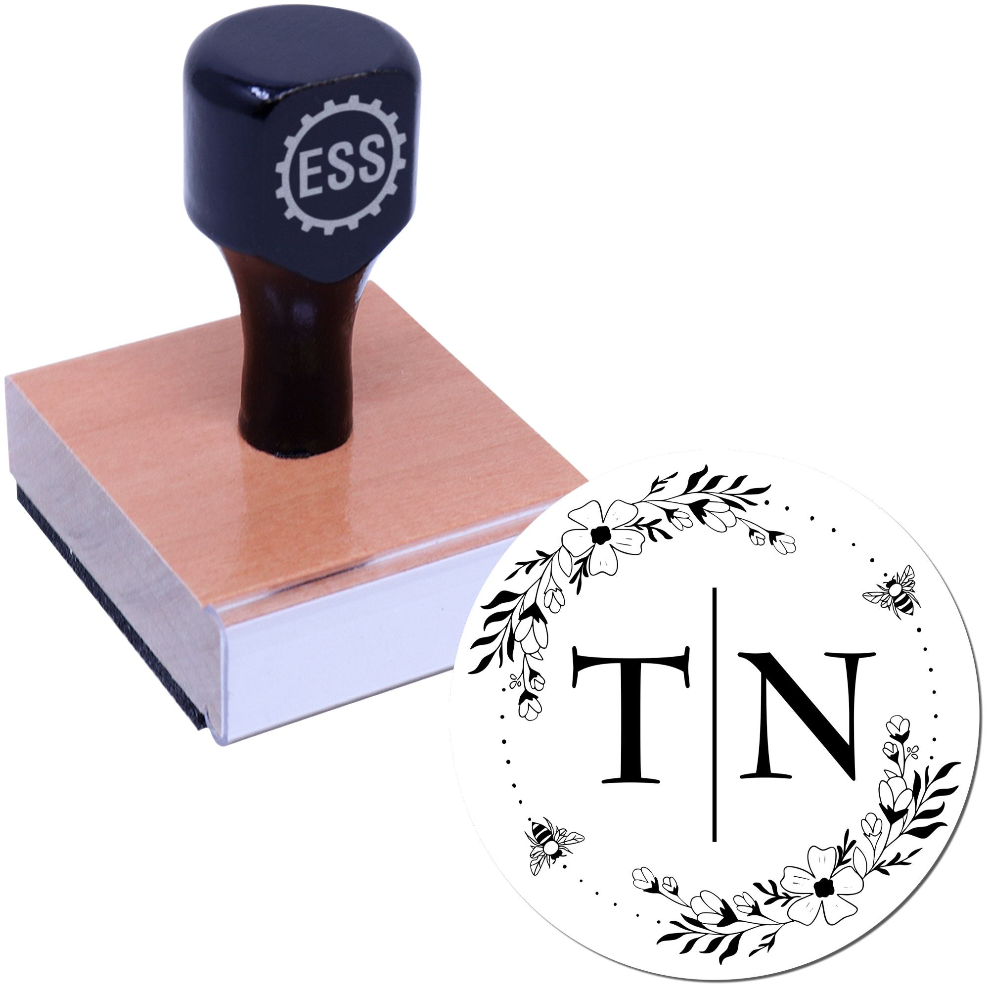 Dark navy ESS stamp handle on wooden block with circular floral TN seal design in black and white.