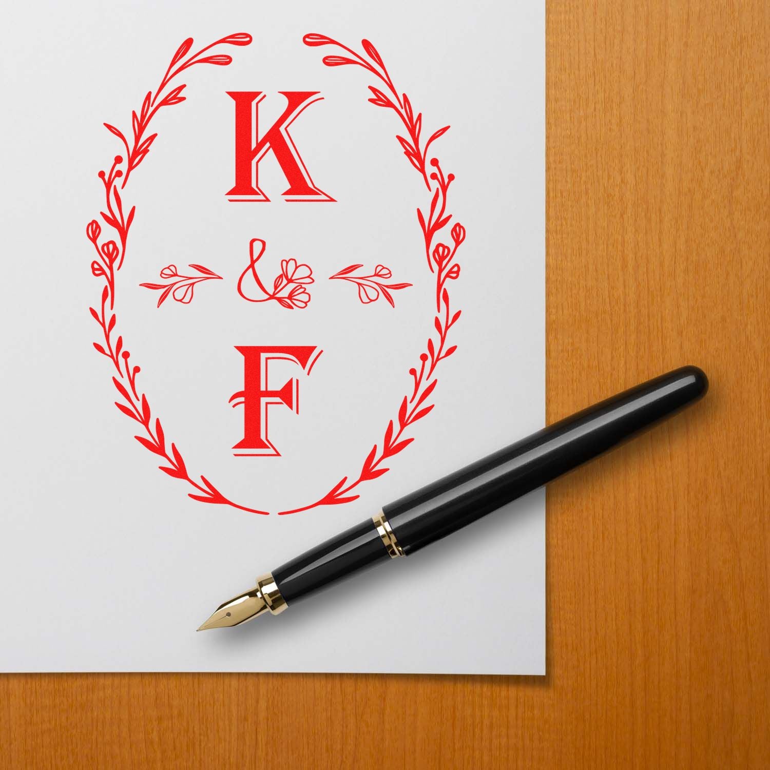 Red K&F monogram wreath seal stamp on white paper with black fountain pen on wood desk