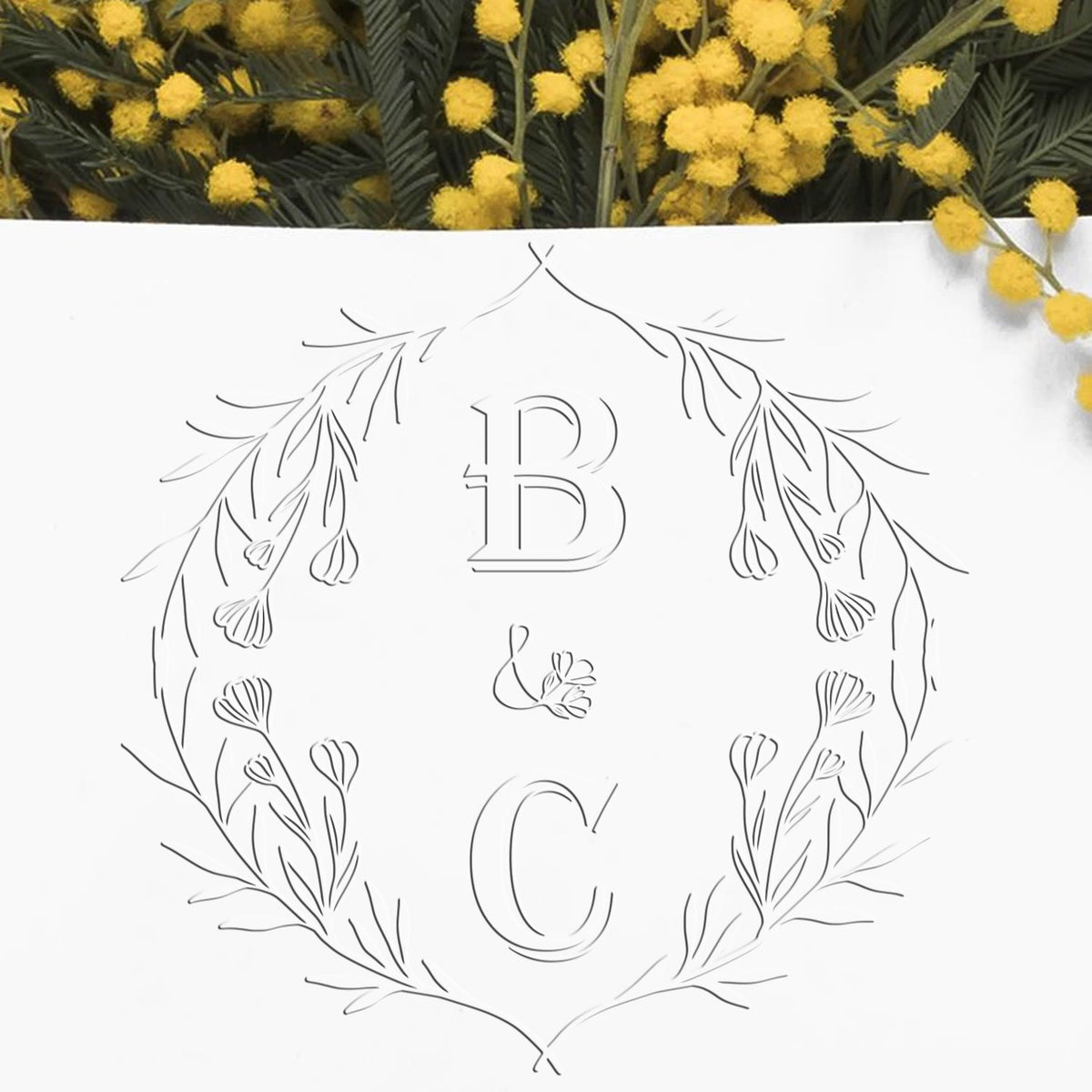 Shiny soft blossom charm monogram wedding invitation seal with embossed initial, used as a decorative wedding stamp.