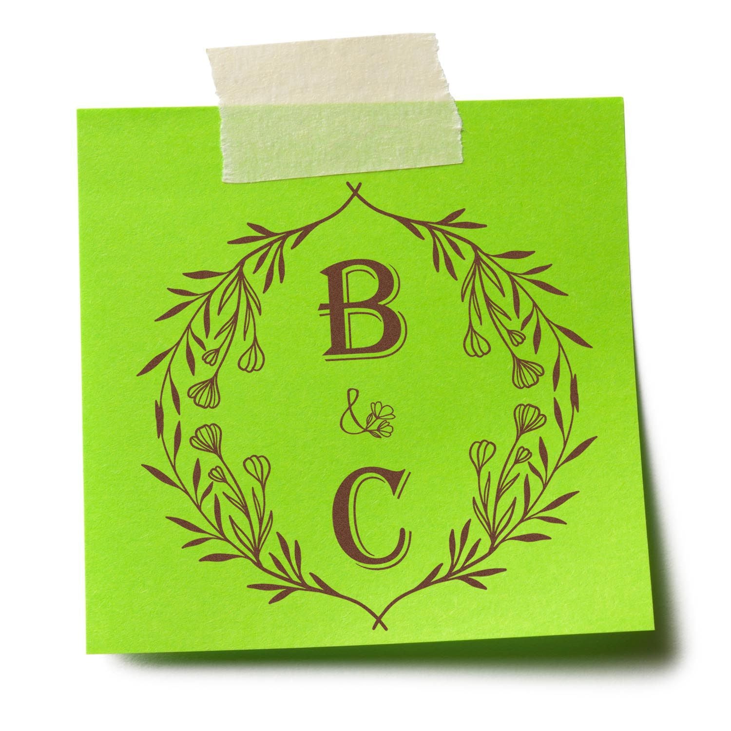 Lime green custom stamp seal with brown B&C monogram in a floral wreath, taped at top with cream masking tape.