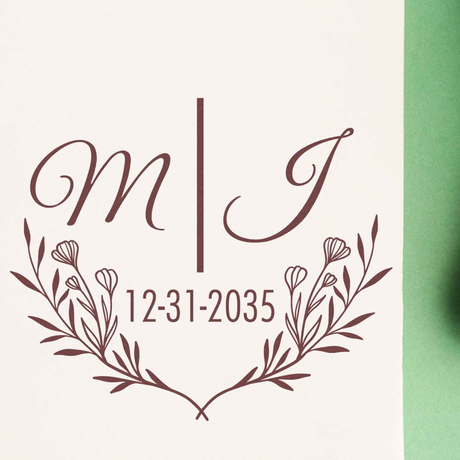 Burgundy custom wedding stamp and seal with monogram M|J, 12-31-2035, and floral wreath on cream paper.