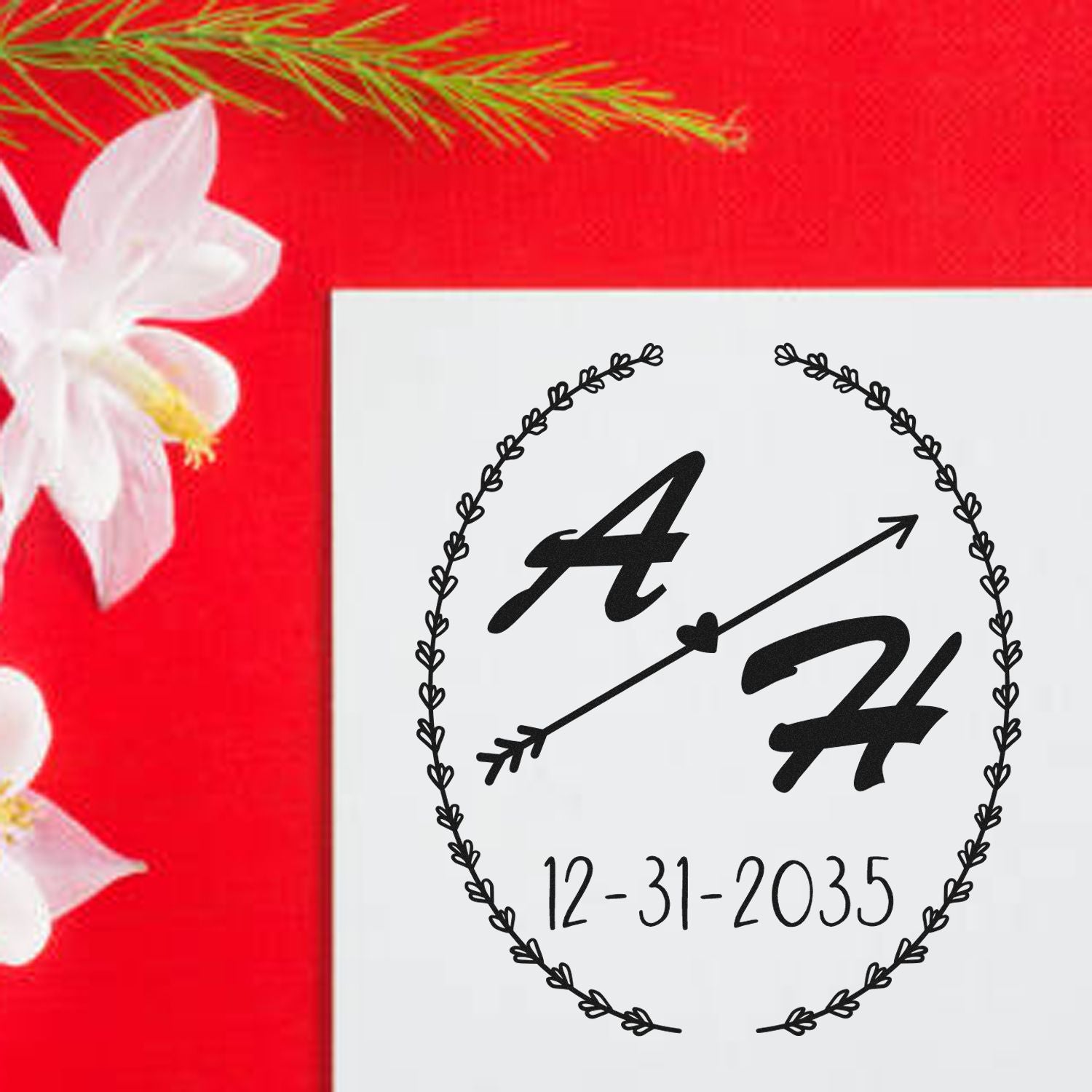 Custom black monogram stamp and seal with A and H, arrow, wreath, and 12-31-2035 on white panel over red floral background.