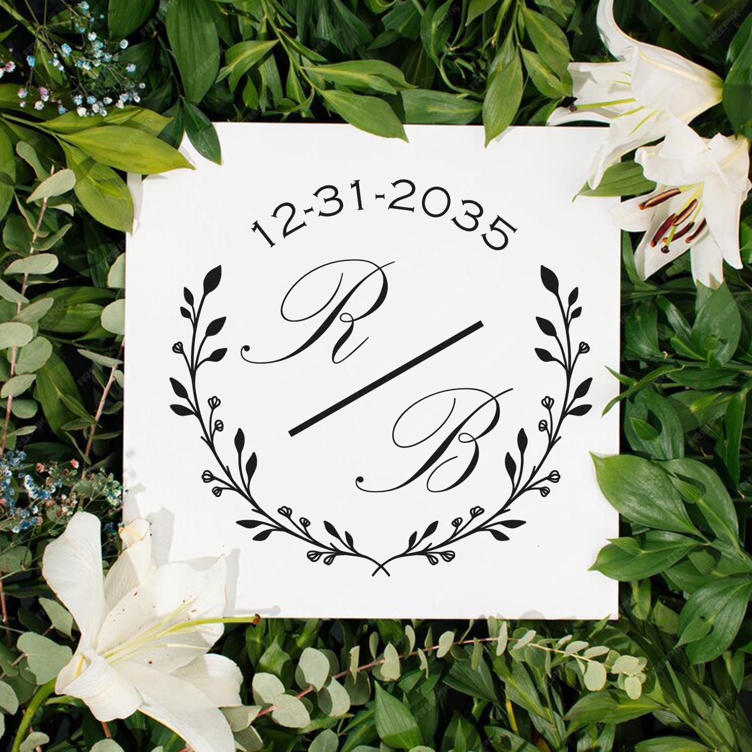 Custom black monogram stamp and seal with 12-31-2035, floral wreath, on a white square amid green leaves and white lilies.