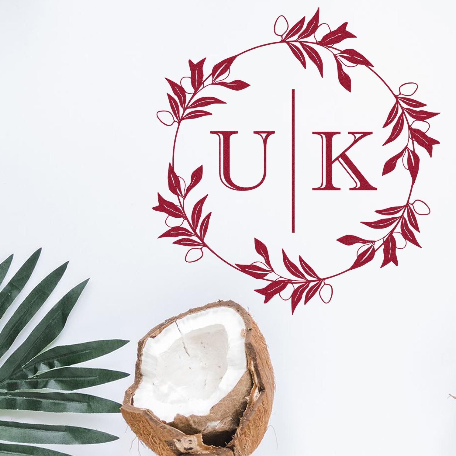 Burgundy floral wreath stamp seal with UK monogram on white background