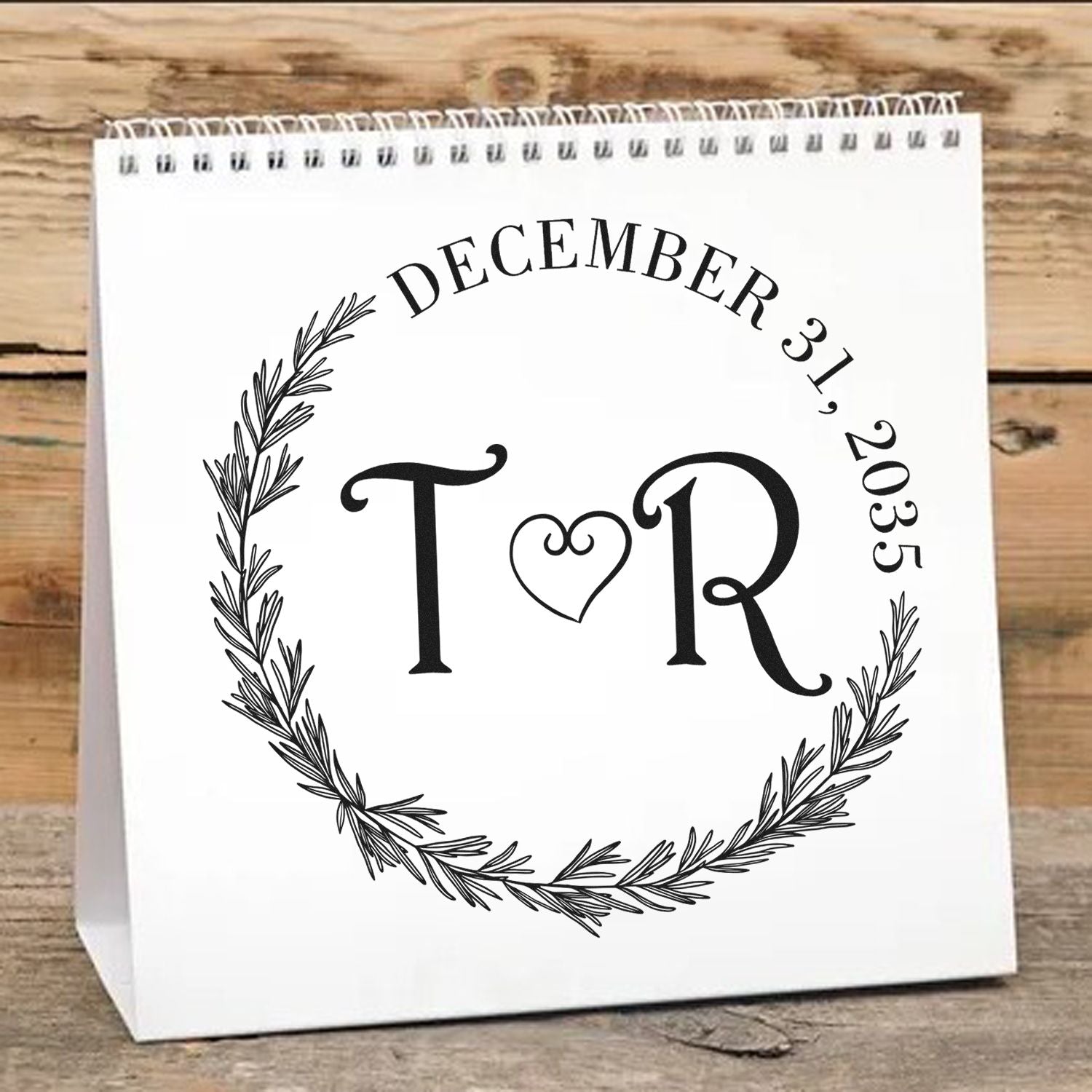 Black custom stamp and seal design with T?R initials, December 31, 2035, and a pine wreath on white.