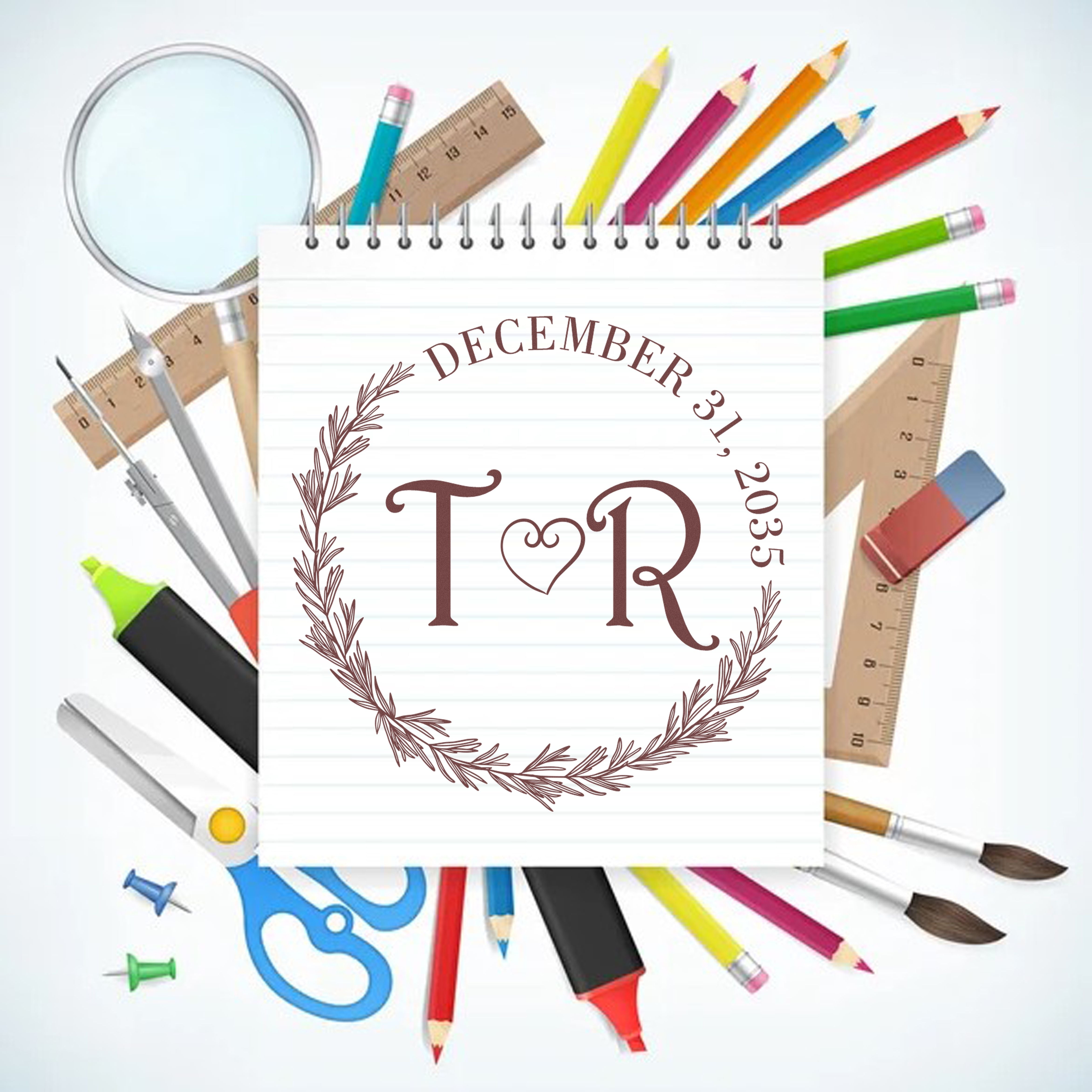 Custom stamp and seal on lined notebook, brown monogram and December 31, 2035, with colorful pencils, rulers, scissors and pens.