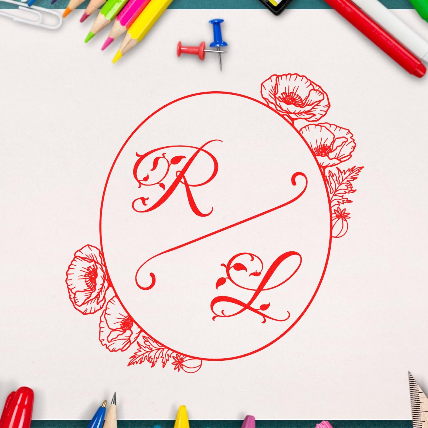 Red floral monogram stamp seal with ornate R and L on white paper, framed by colorful pencils and push pins.