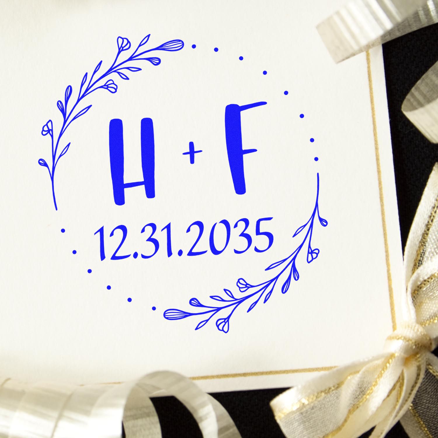 Blue floral wedding stamp seal with H+F monogram and 12.31.2035 date on cream card.