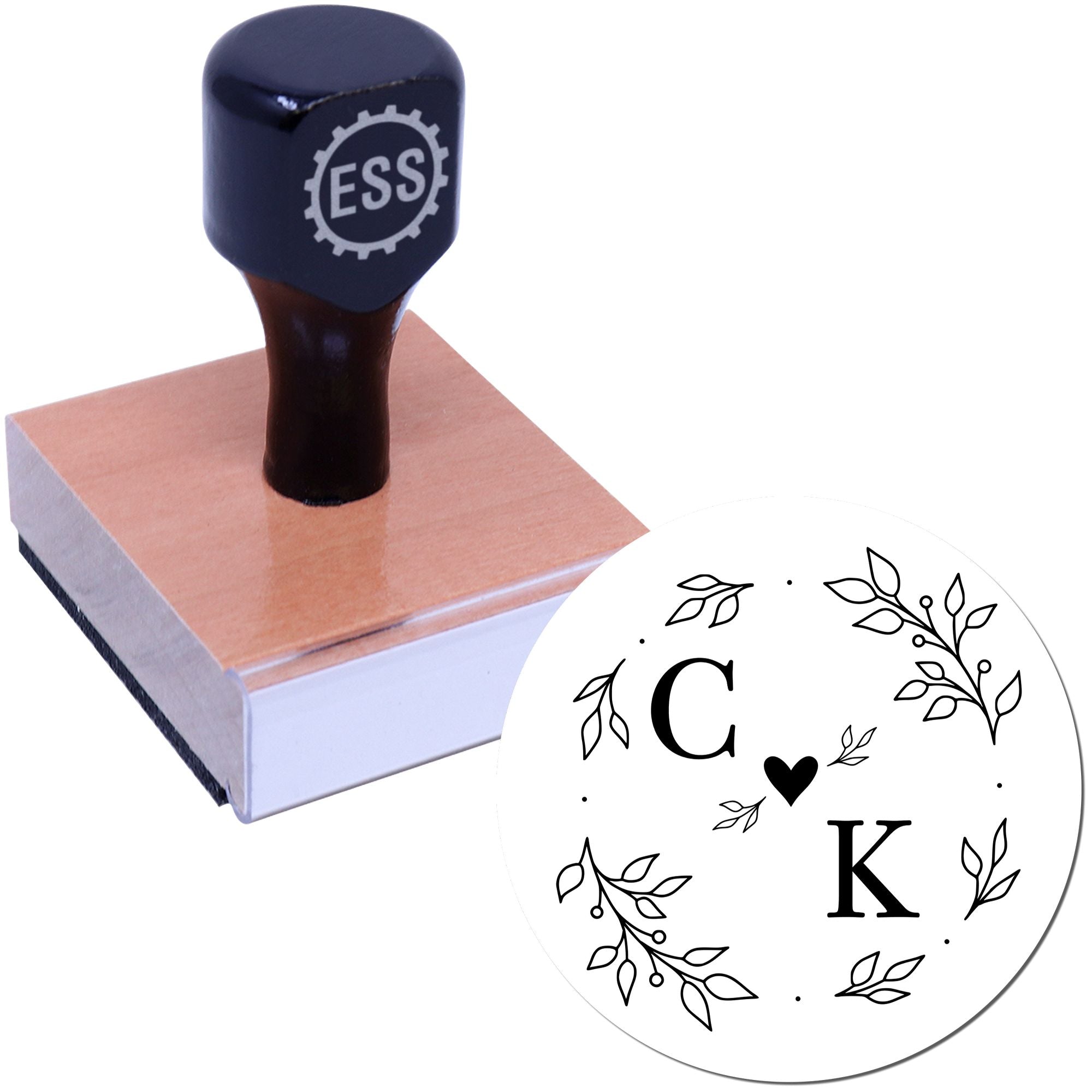 Dark navy self-inking stamp on square wooden base with custom circular seal design, black C and K, heart, and leafy accents.