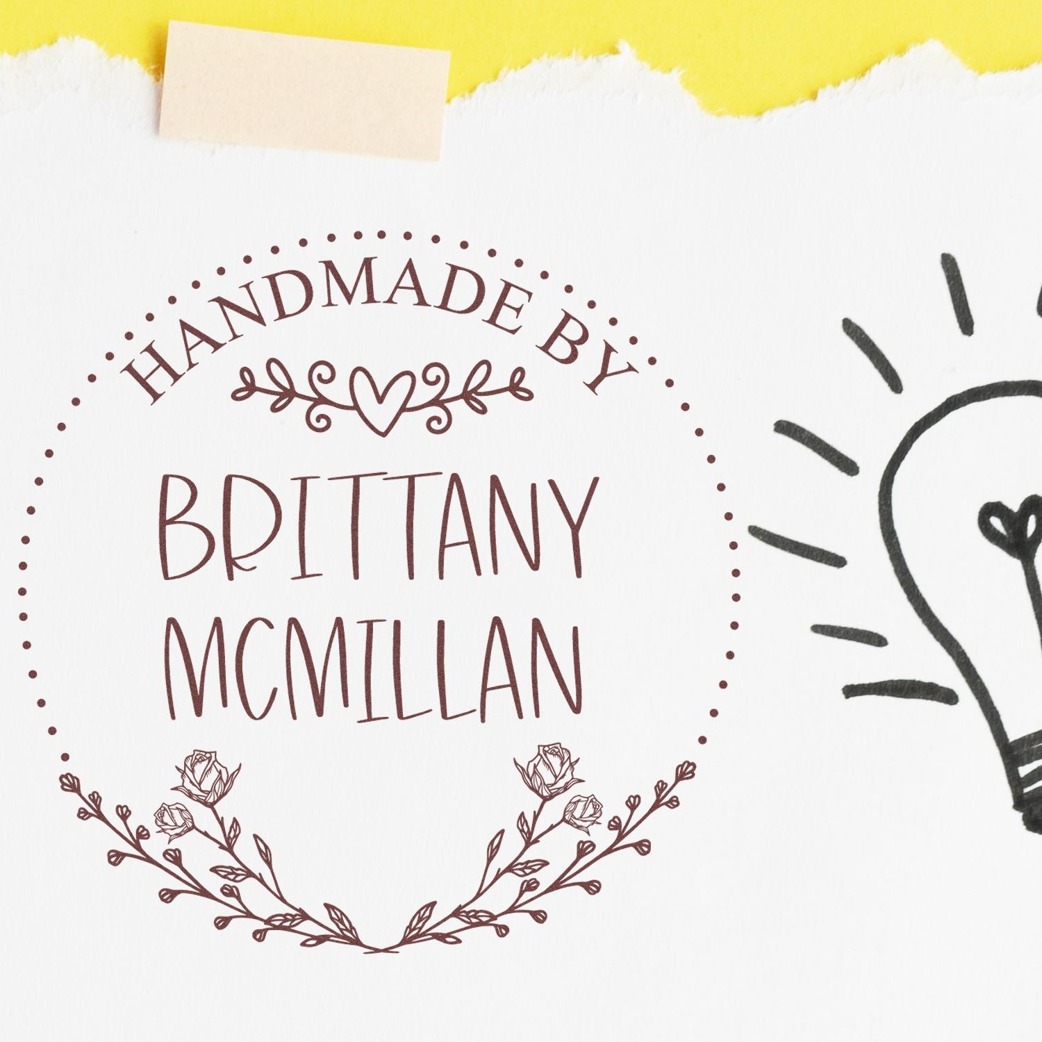 Brown handmade stamp seal reading “Handmade by Brittany McMillan” with floral accents on white paper and yellow torn border