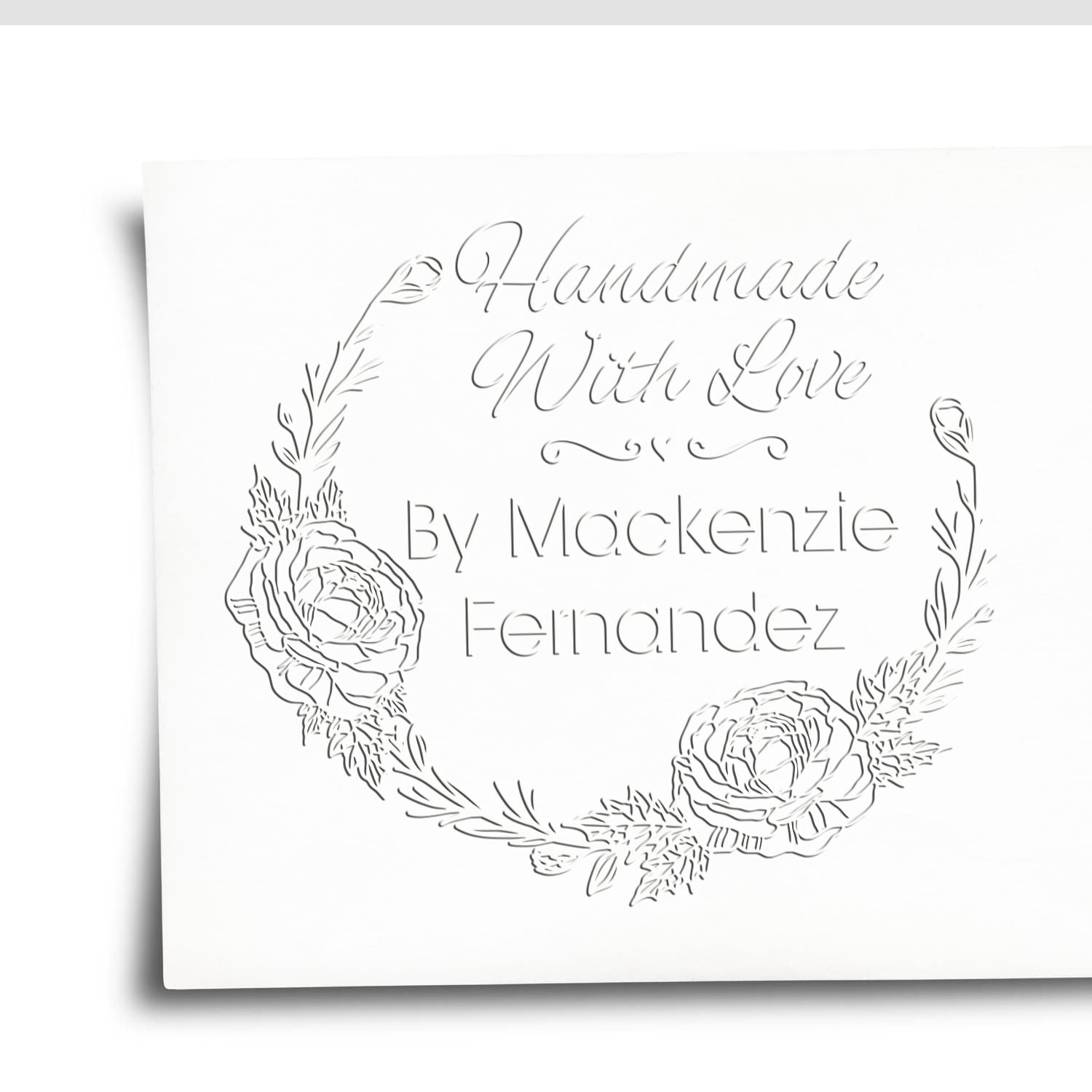 White custom stamp seal with floral wreath and script text, Handmade With Love by Mackenzie Fernandez.