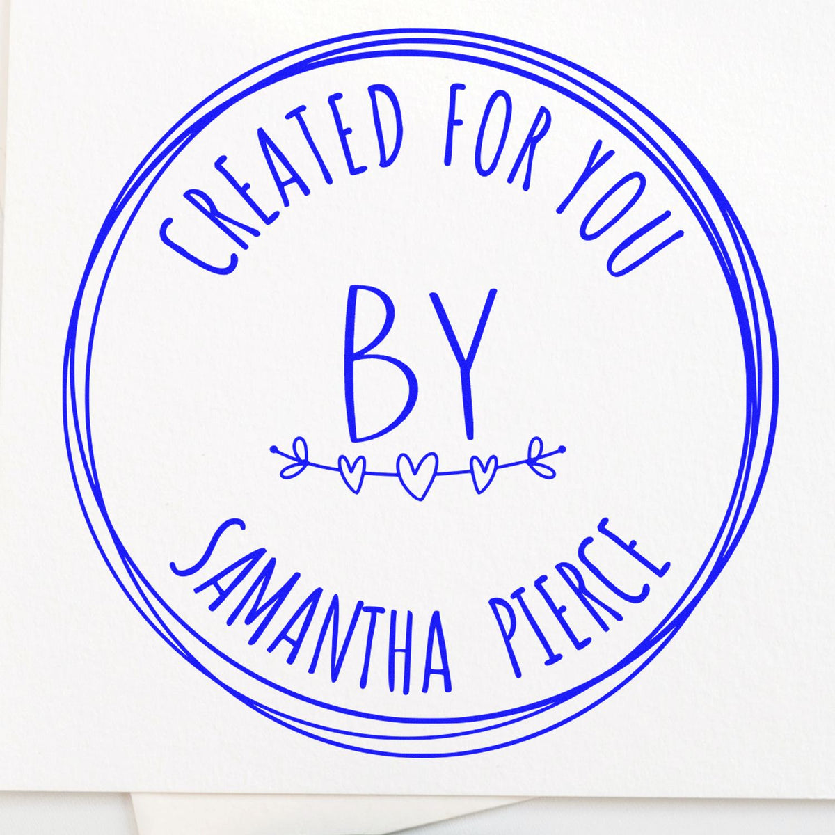 Handcrafted round rubber love stamp by ESS in use, showcasing intricate design on a stamping surface.