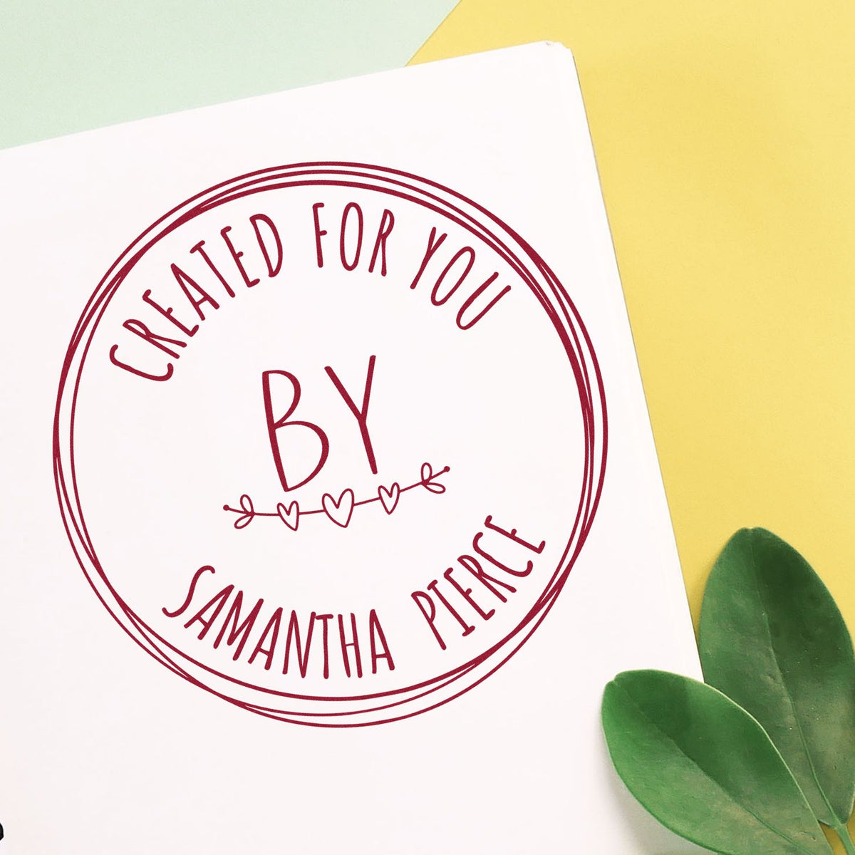Round handcrafted love rubber stamp by ESS in use, showcasing intricate design on a white background.