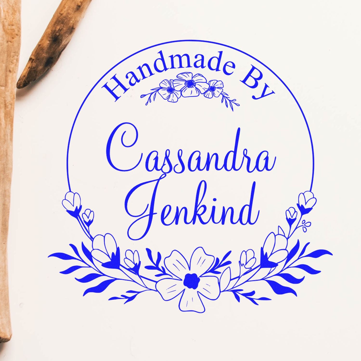 Blue floral handmade stamp seal for Cassandra Jenkind, with ornate wreath and blossoms on a white background.