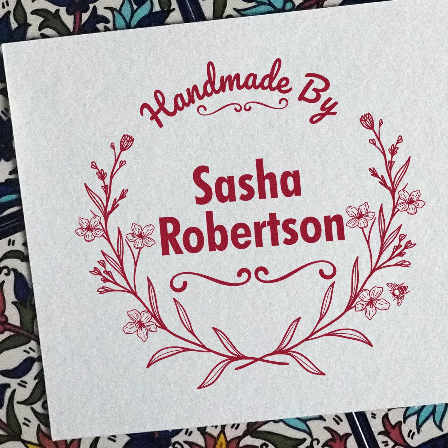 Red floral handmade stamp seal for Sasha Robertson on white paper