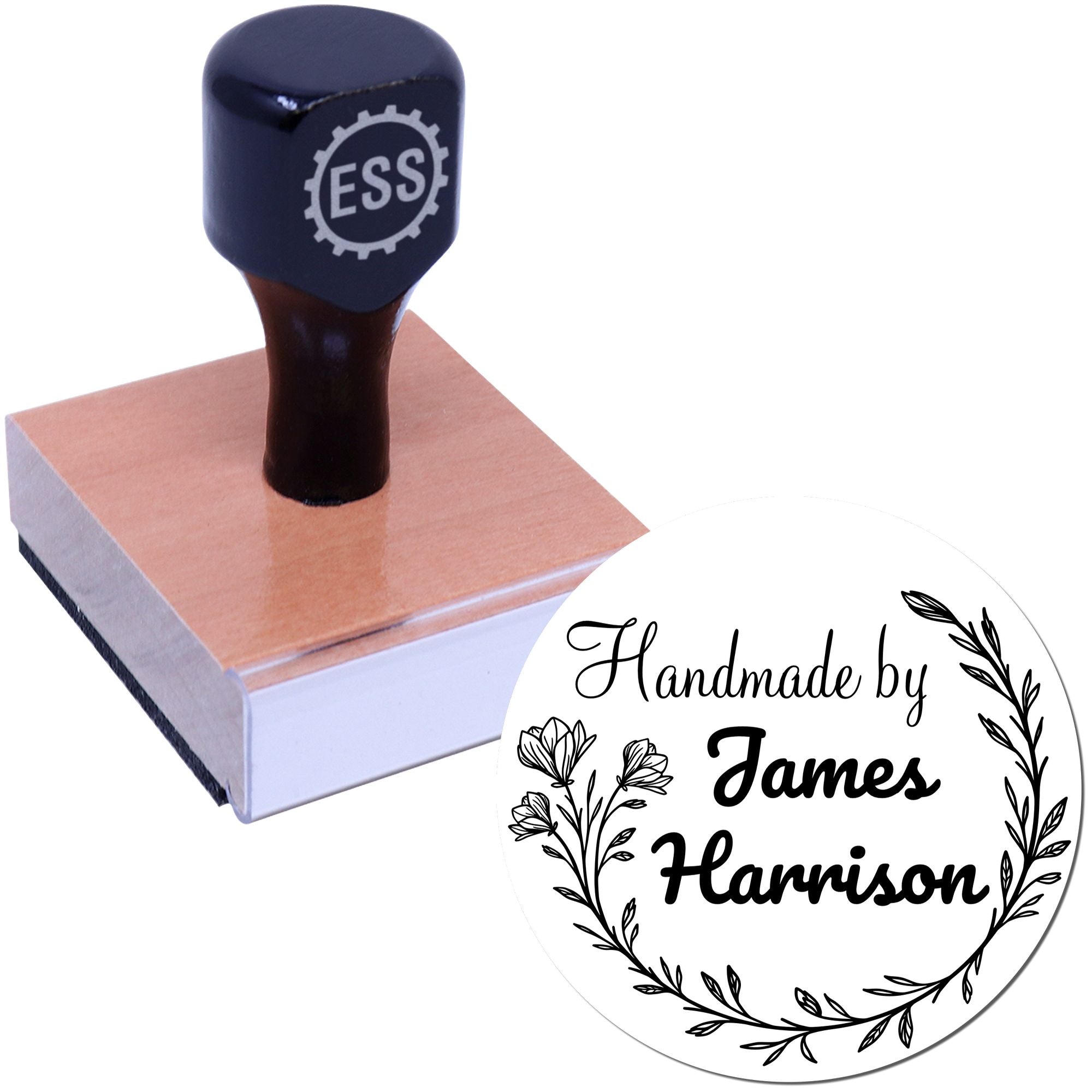 Black custom rubber stamp on a wooden block with round seal reading Handmade by James Harrison, floral wreath accents.