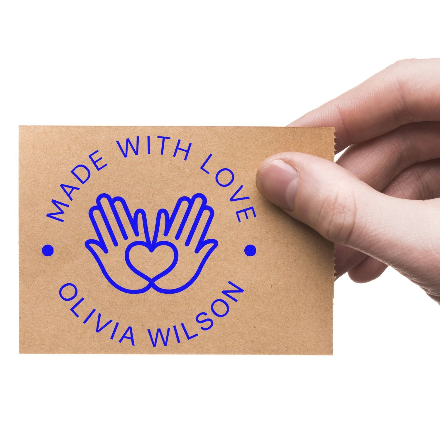 Blue Made with Love stamp and seal with heart-in-hands logo on tan kraft paper, held by a hand.