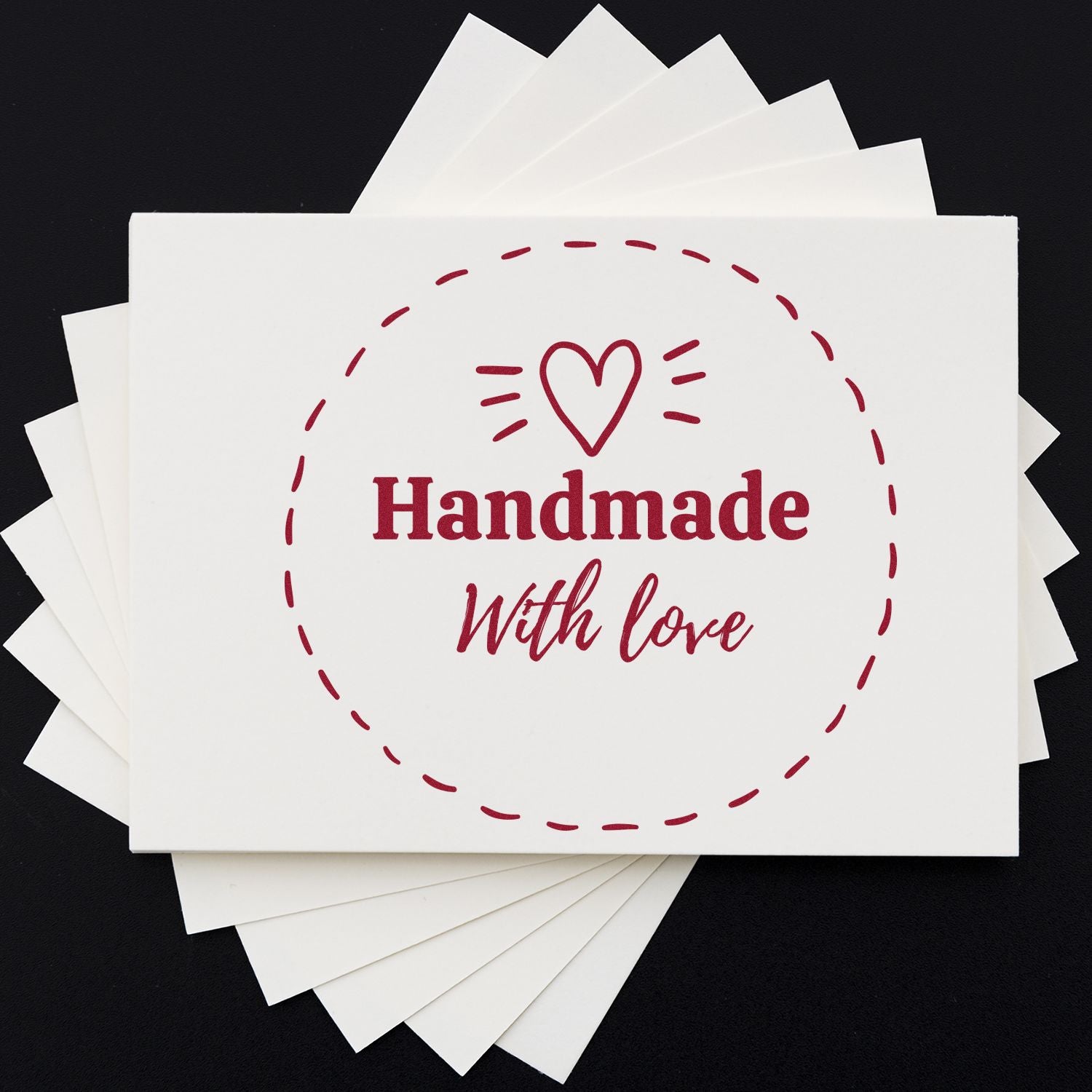 White stamp and seal cards with burgundy heart icon and Handmade With Love in a circular design on black background.