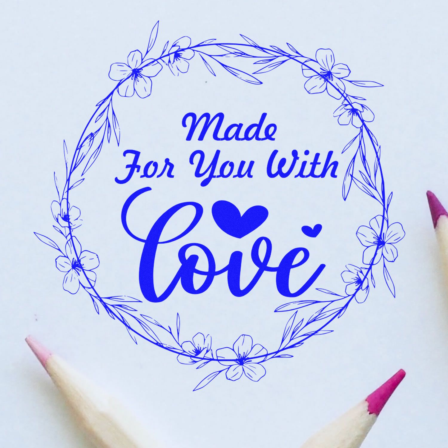 Blue floral rubber stamp seal with wreath border and text Made For You With Love in bright blue on white paper.