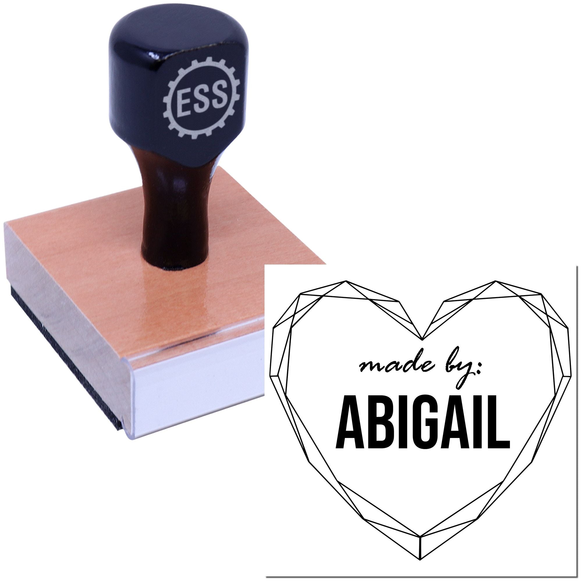 Black ESS rubber stamp on a rose-gold wooden base with a heart-shaped geometric seal reading "made by: ABIGAIL".