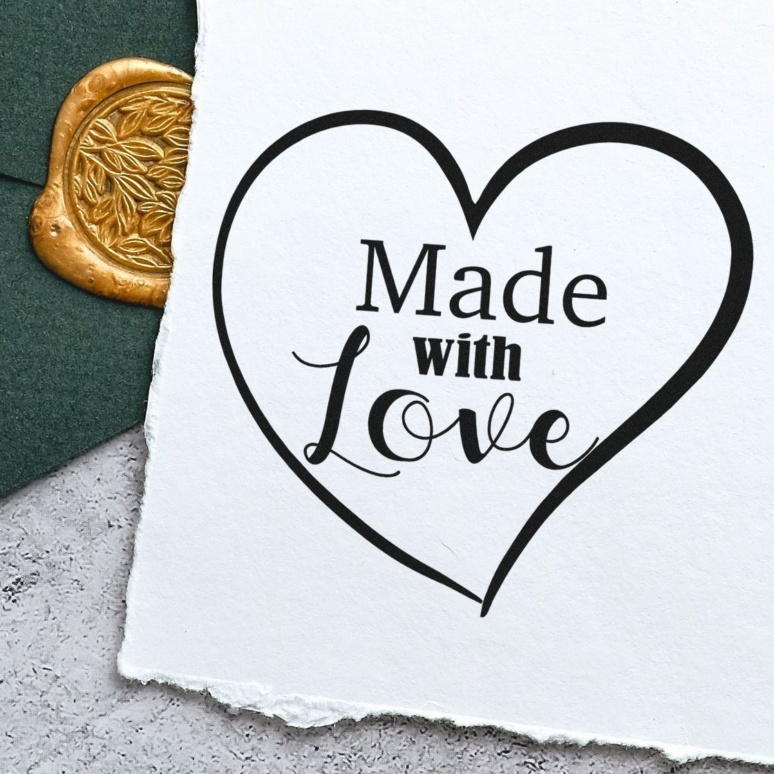 Heart-shaped Made with Love stamp in black on white paper beside a gold embossed wax seal product.