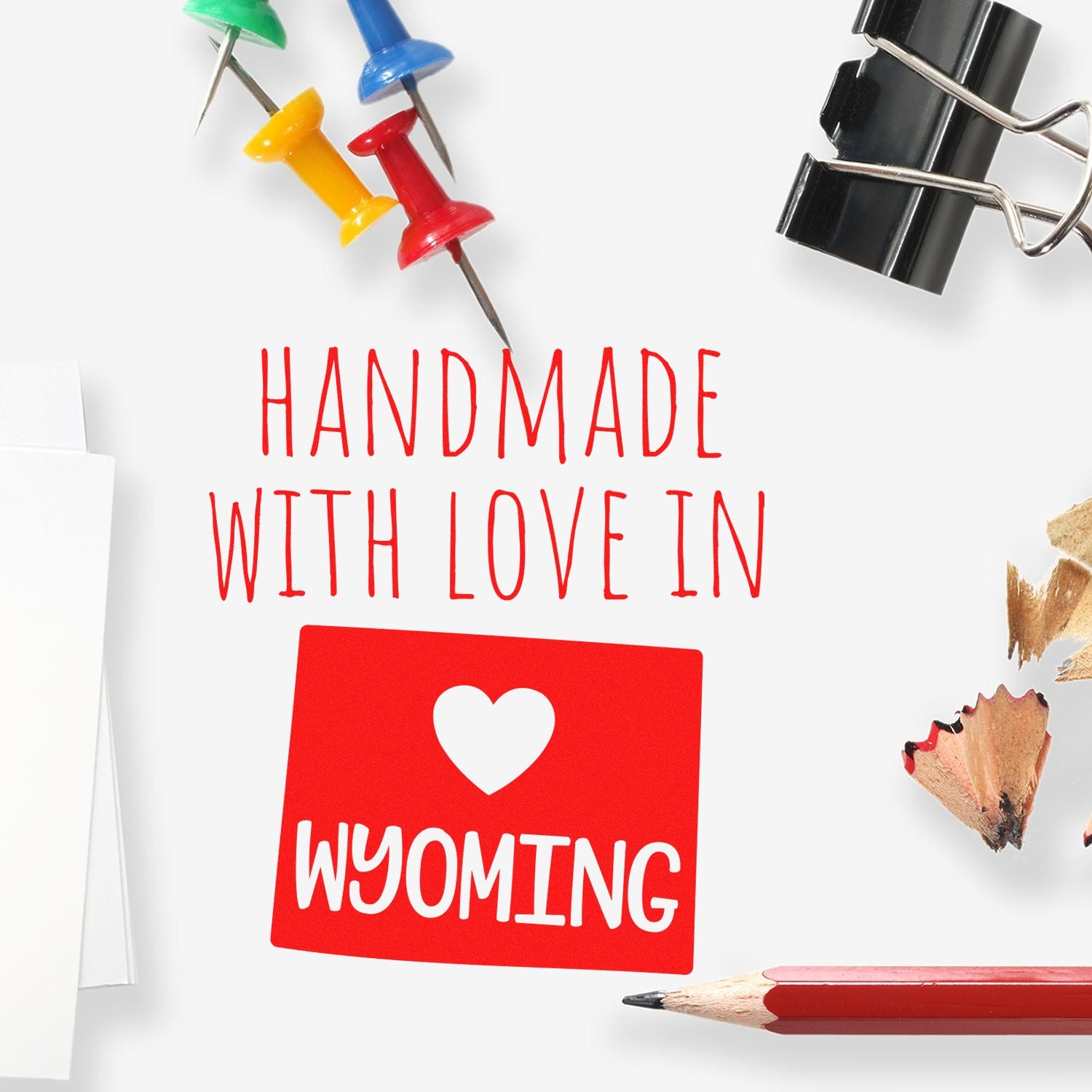 Wood handle Wyoming handmade rubber stamp by ESS, in use, showing detailed design and sturdy wooden handle.