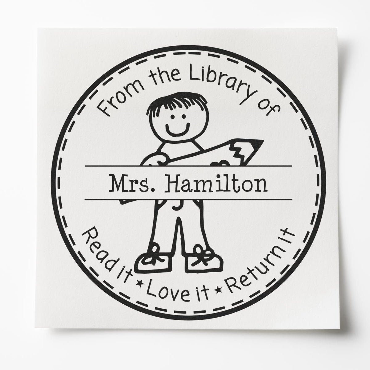 Black circular library stamp seal with child holding pencil, reading From the Library of Mrs. Hamilton Read it Love it Return it