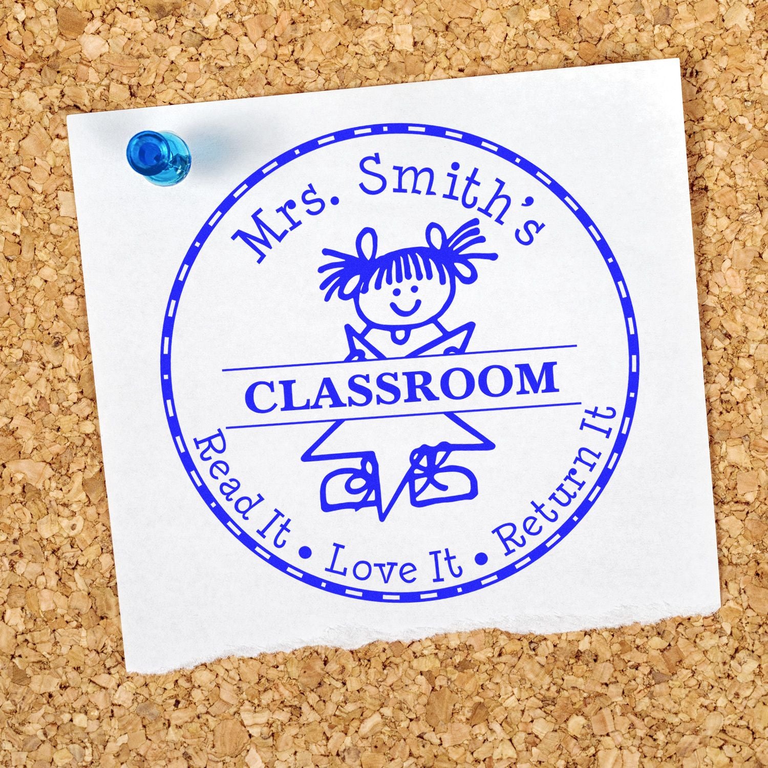 Blue classroom stamp and seal reading Mrs. Smiths Classroom, Read It Love It Return It on white paper pinned to corkboard.