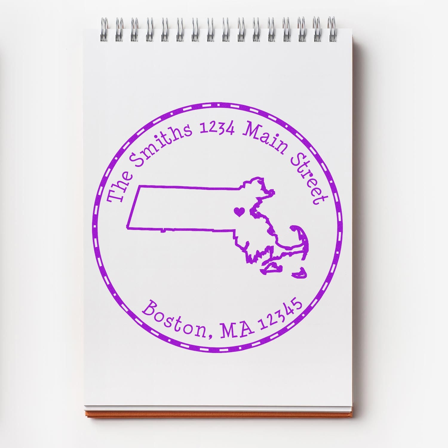Purple custom stamp seal on white notepad with Massachusetts outline, heart, and Boston, MA 12345.