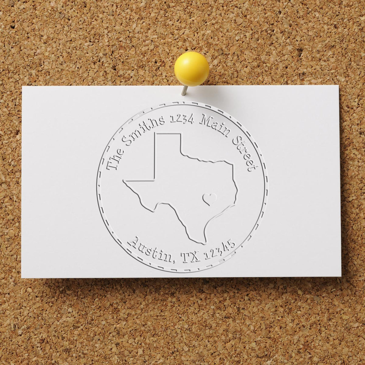 Custom Texas address stamp seal on white card, embossed outline, pinned with a yellow pushpin on corkboard.