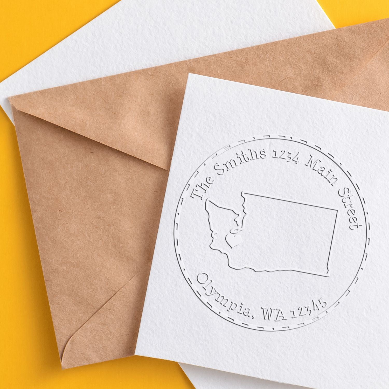 Custom stamp and seal embossing on white card and brown envelope with circular Washington address, on a yellow background.