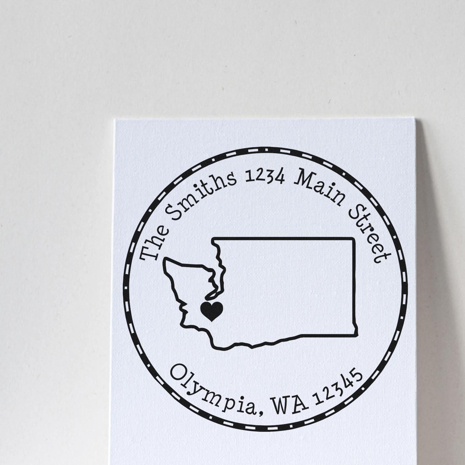 Black custom return address stamp seal with Washington outline and heart on white textured card, reading The Smiths, Olympia WA 12345.