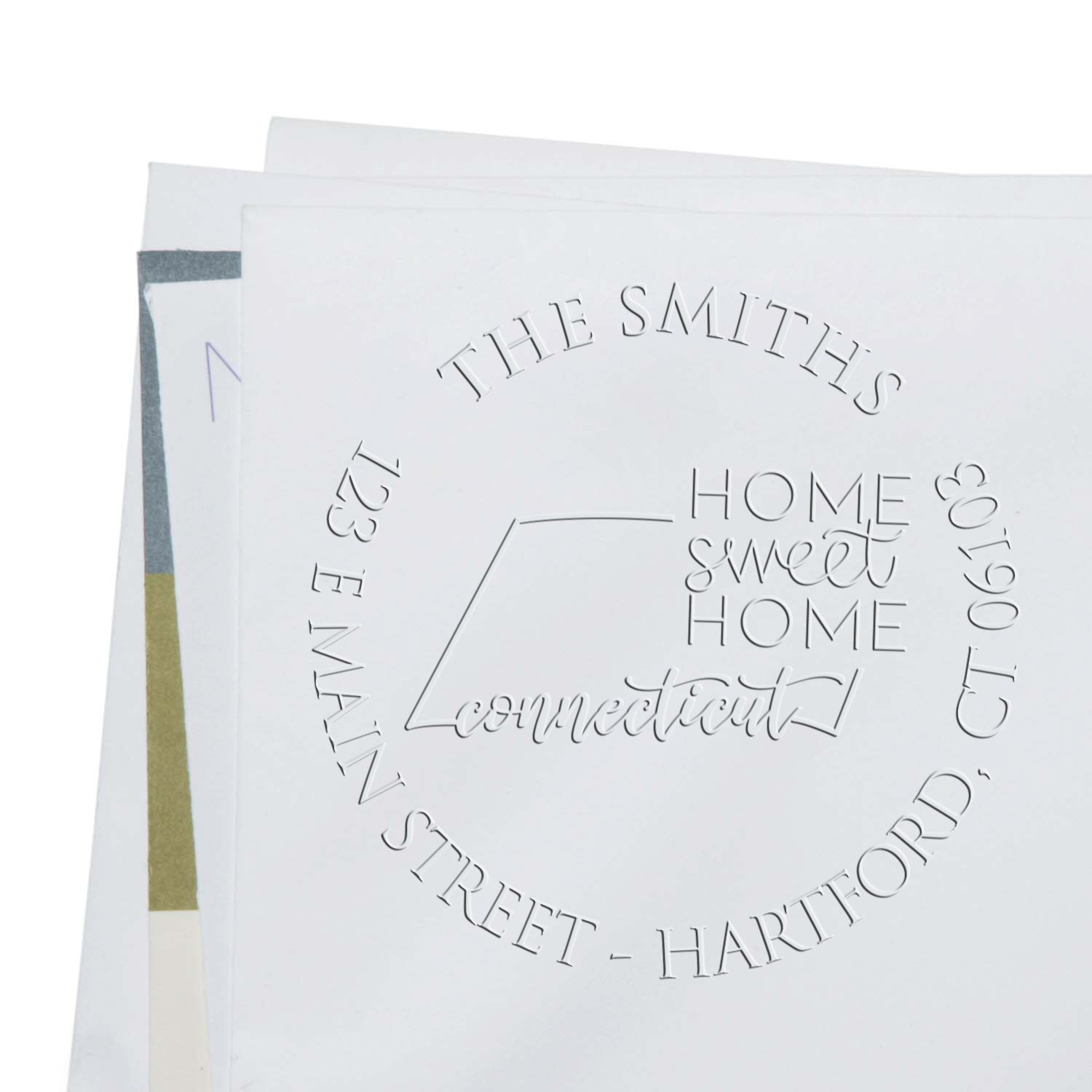 White custom embossing stamp seal with circular The Smiths home sweet home connected text on white paper.