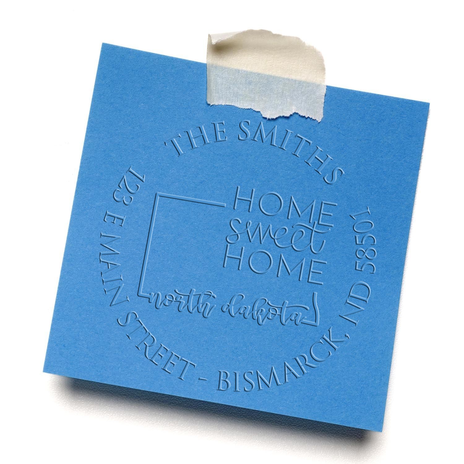 Blue embossed stamp and seal sample with Home Sweet Home, white torn tape, and circular family address design on blue paper.
