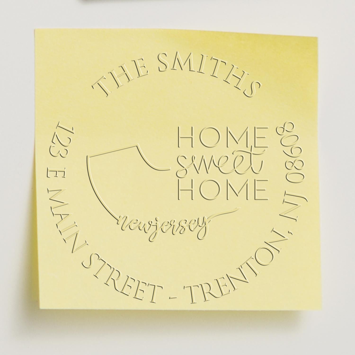 Pale yellow embossed stamp seal design with circular The Smiths and Home Sweet Home New Jersey text.
