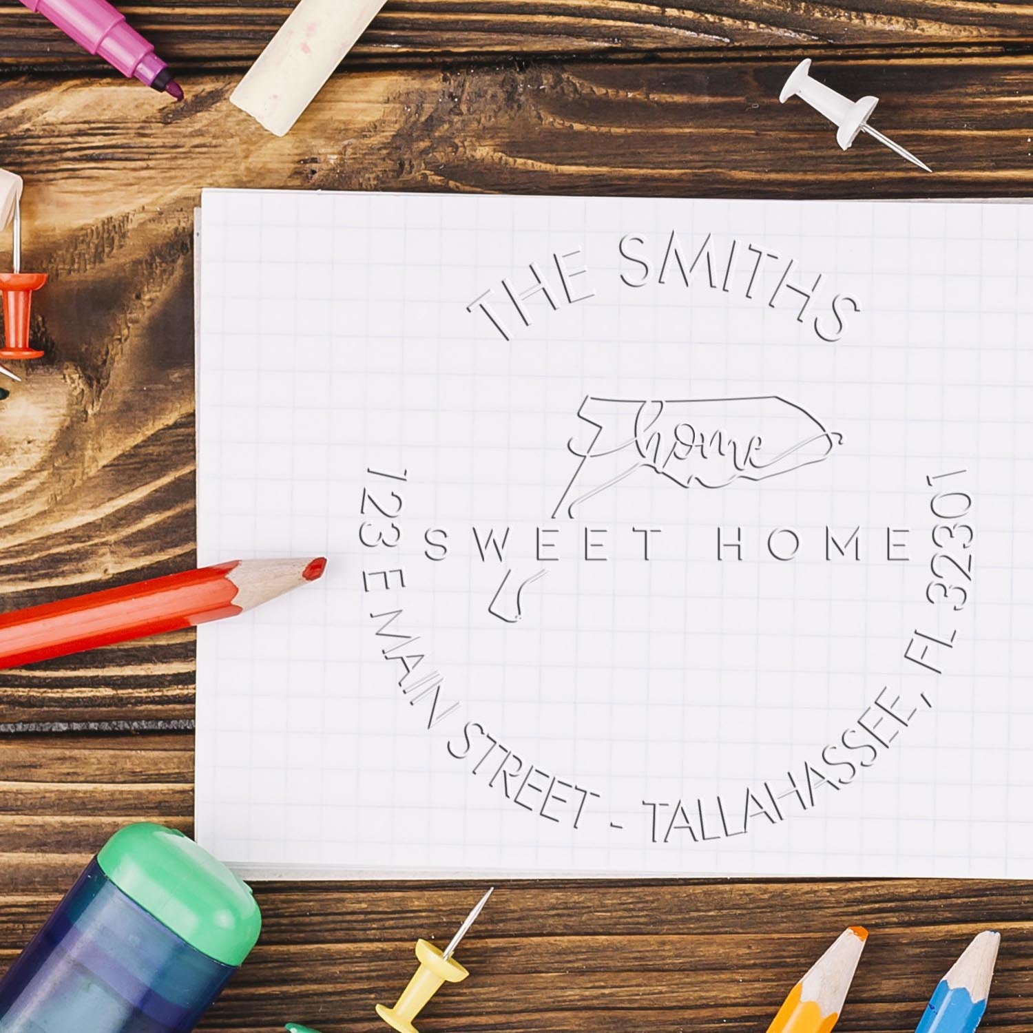 Custom stamp and seal layout on white paper, with THE SMITHS Sweet Home, colored pencils, and push pins on rustic wood.