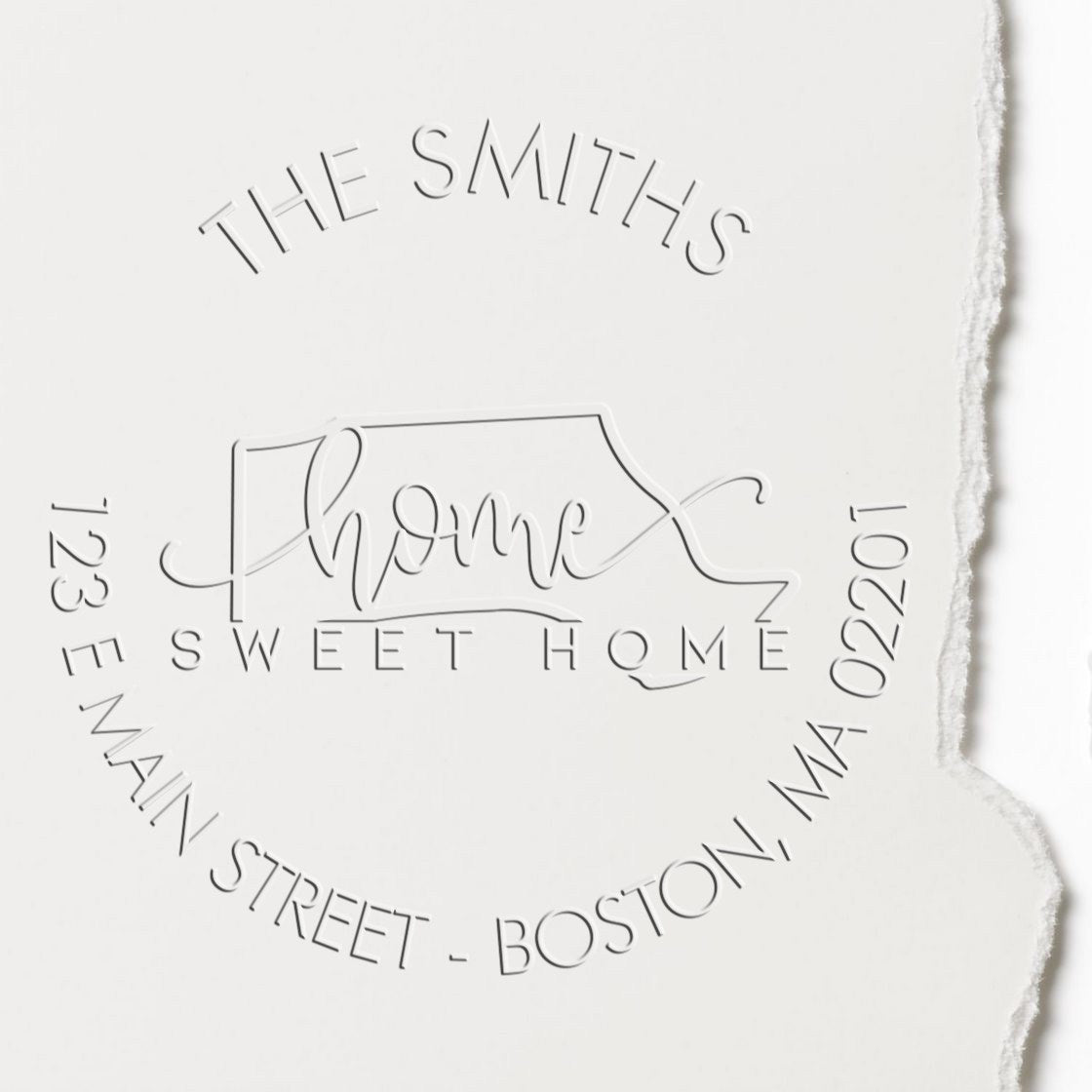 White embossed custom stamp seal with house outline, The Smiths Home Sweet Home, and address text around the edge.