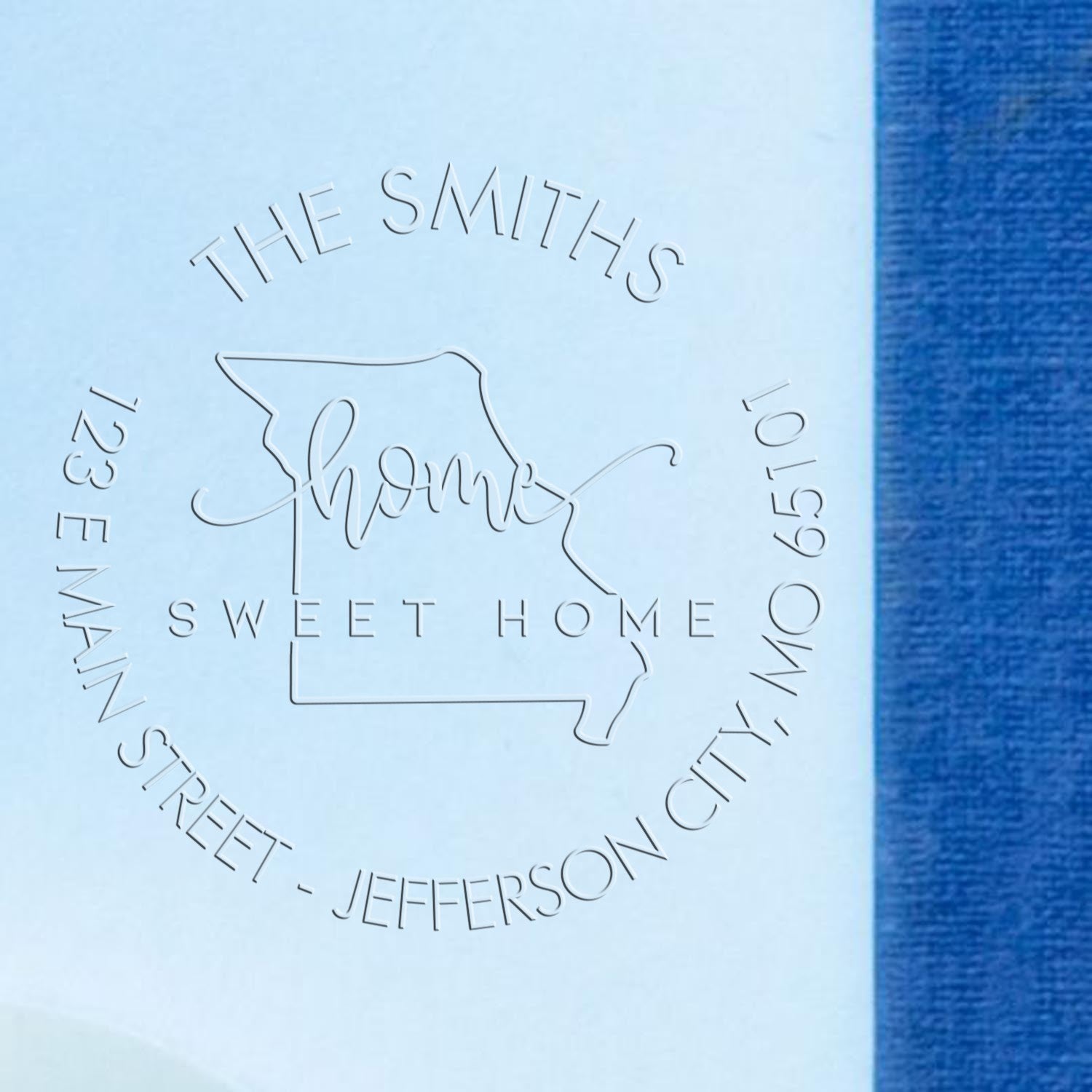 White embossed stamp seal for The Smiths Sweet Home, with Missouri outline on a blue background.