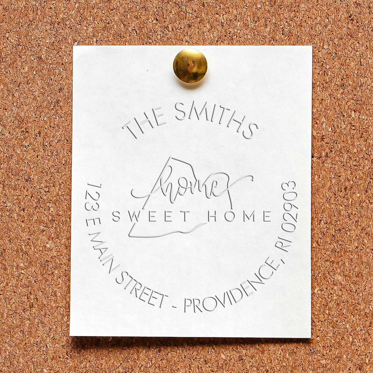 Custom embossed white stamp and seal card pinned with brass tack on corkboard, reading The Smiths Sweet Home in silver