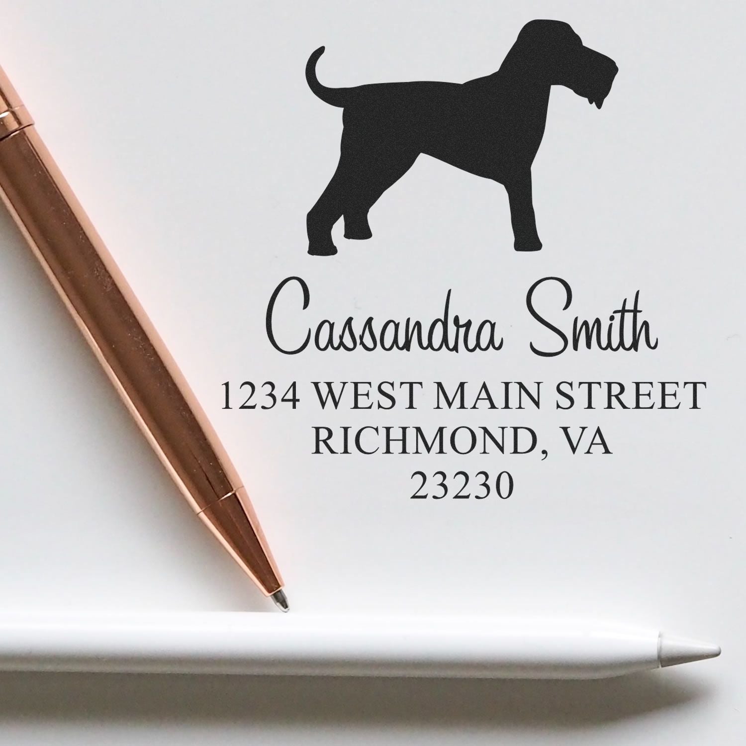 Custom white address stamp and seal with black dog silhouette, black lettering, and rose-gold pen.
