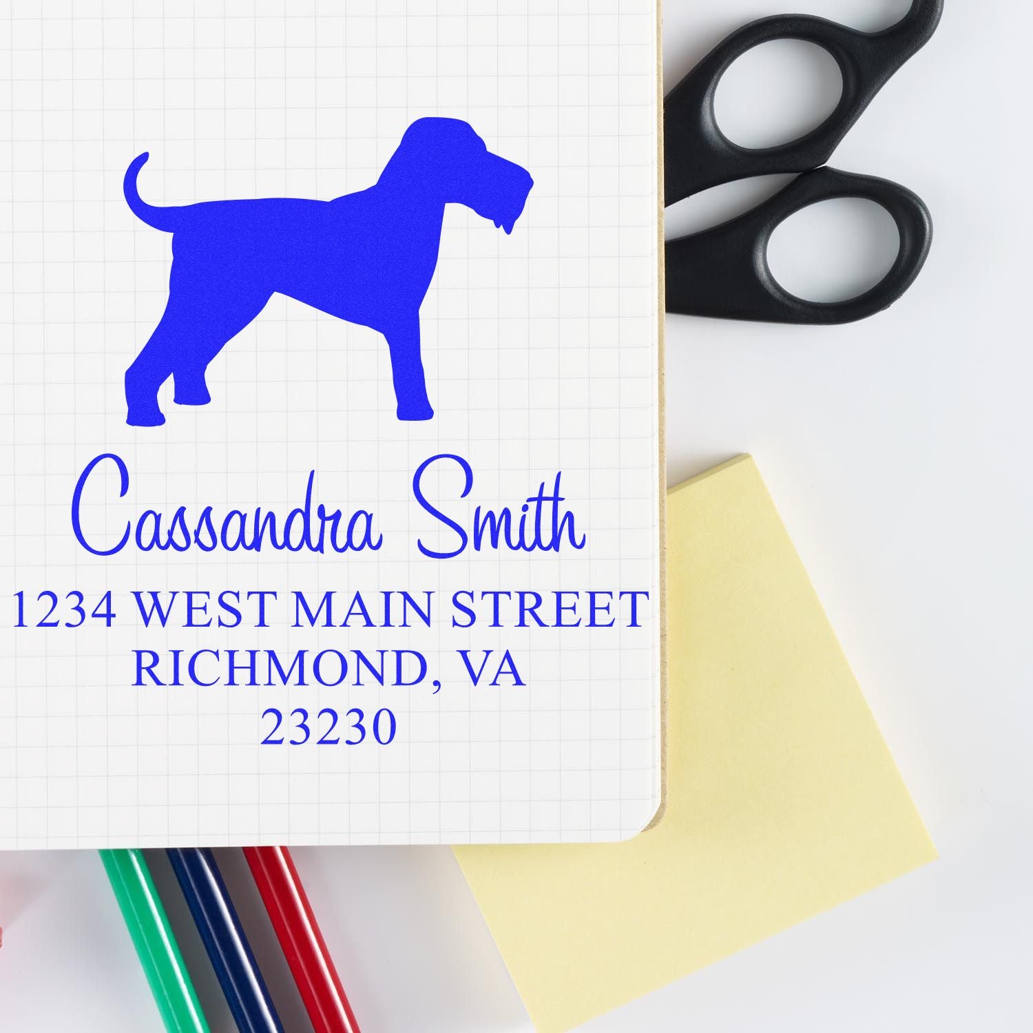 Blue custom stamp and seal with dog silhouette, Cassandra Smith, Richmond, VA, plus black scissors, sticky note, and pens.
