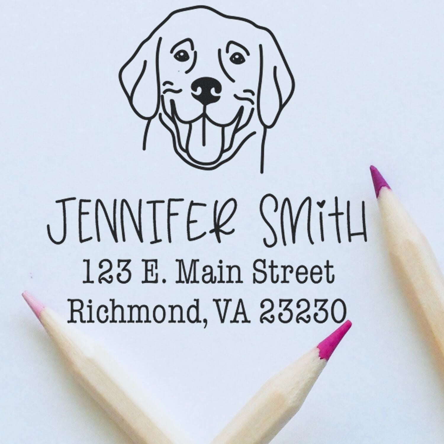 Custom address stamp with black dog logo, Jennifer Smith, 123 E. Main Street, Richmond, VA 23230, on white paper with pink pencils.
