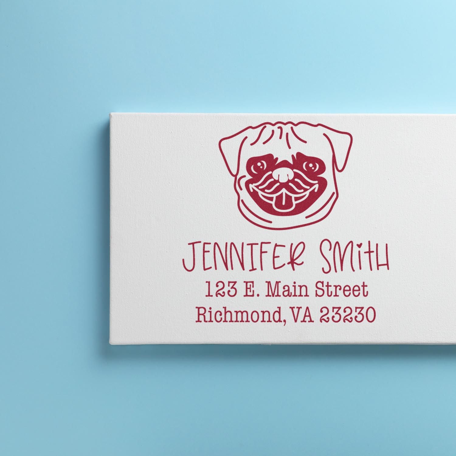 Red custom address stamp and seal with dog logo on white block, set on light blue background.