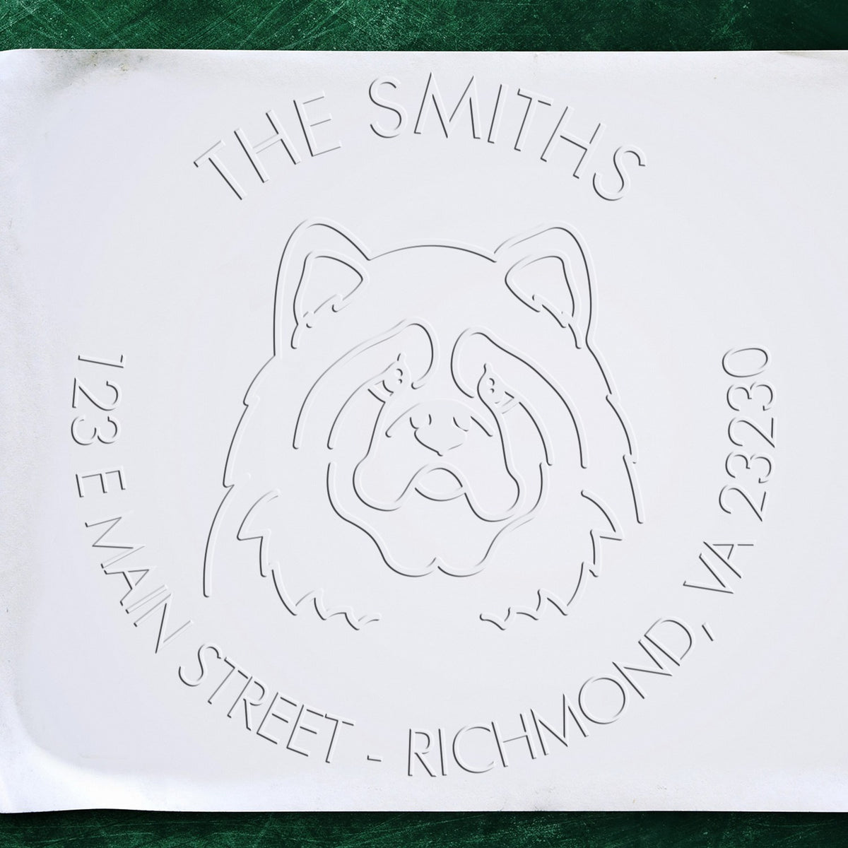 Shiny personalized return embossed dog stamp featuring a Chow Chow design being used to stamp on paper.