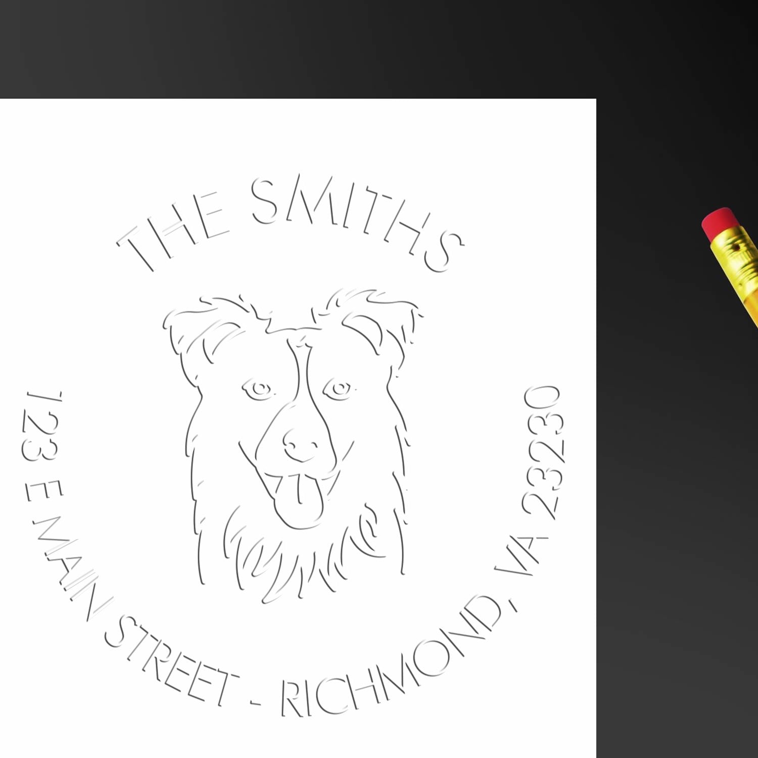 White custom stamp seal with line-art dog logo, black lettering, and address details; pencil at right on dark background.