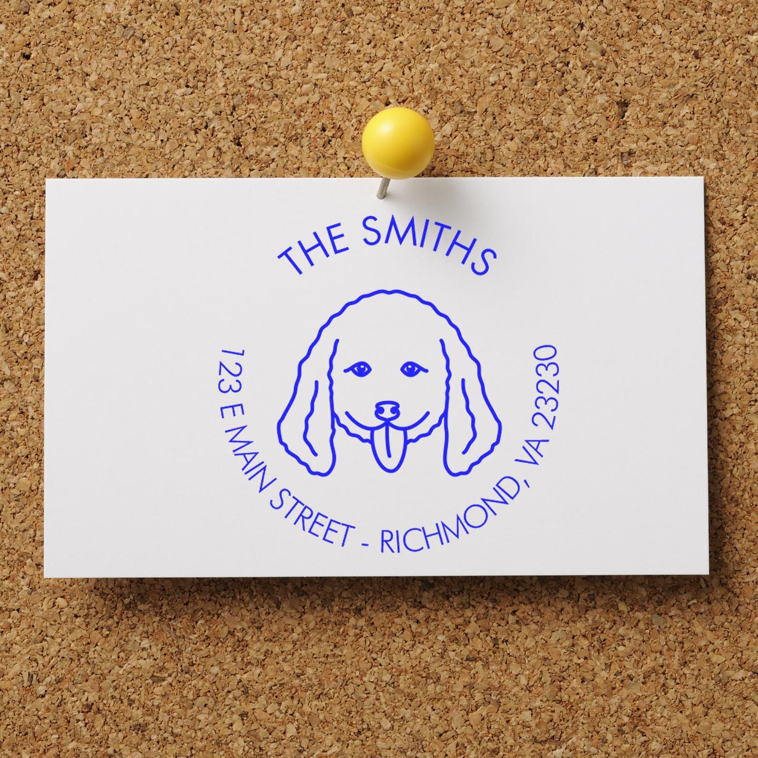 Dog-shaped rubber address stamp with wood handle from ESS, featuring a custom doodle design, in use on paper.